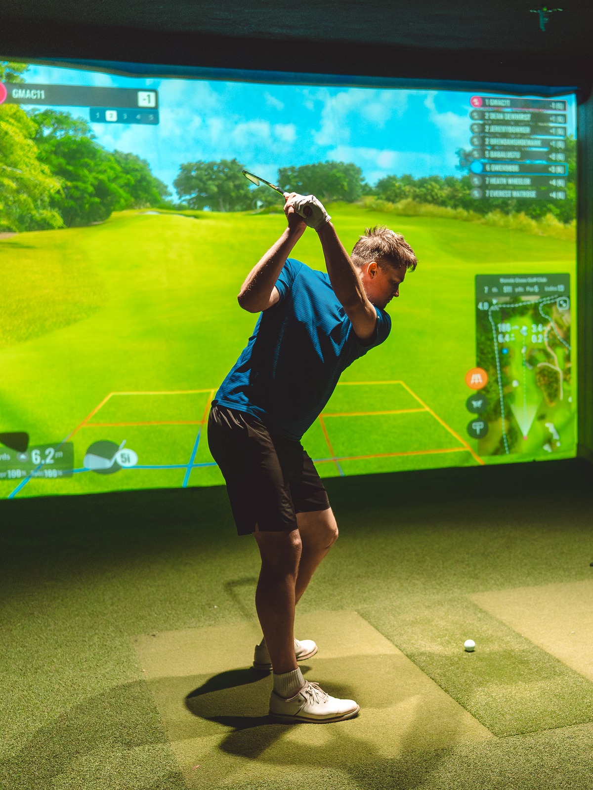 Focused golfer at the top of the backswing.