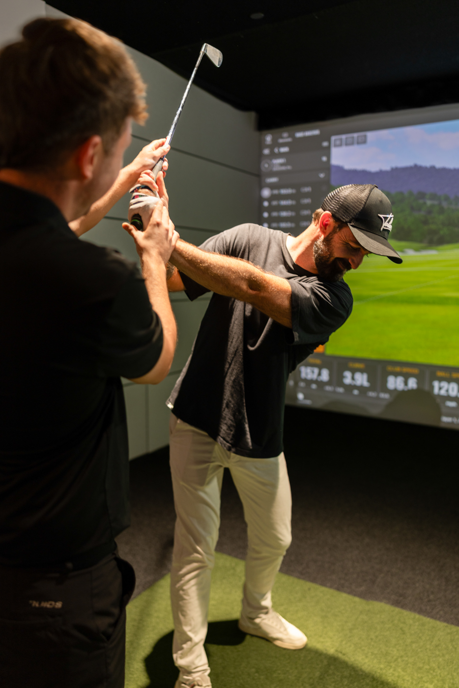 GolfSpace PGA coach working through swing mechanics with a player on the simulator.